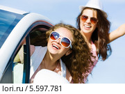 Две красивые девушки в солнцезащитных очках едут на автомобиле, высунувшись из окна. Стоковое фото, фотограф Sergey Nivens / Фотобанк Лори