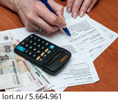 Женщина рассчитывает деньги на коммунальные услуги (2014 год). Редакционное фото, фотограф Игорь Низов / Фотобанк Лори