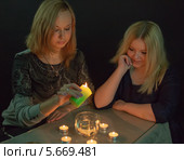 Две девушки сидят за столом со свечами. Стоковое фото, фотограф Юрий Викулин / Фотобанк Лори