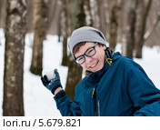 Счастливый парень-подросток играет в снежки в лесу. Стоковое фото, фотограф Игорь Низов / Фотобанк Лори