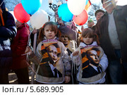Дети в манишках с фотографией президента Владимира Путина на митинге в поддержку русских на Украине в Новопушкинском сквере города Москвы 10 марта 2014. Редакционное фото, фотограф Николай Винокуров / Фотобанк Лори