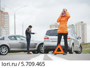 Авария. Мужчина и женщина стоят около своих машин и разговаривают по мобильным телефонам. Стоковое фото, фотограф Дмитрий Калиновский / Фотобанк Лори