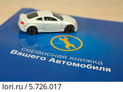 Сервисная книжка автомобиля и игрушечный автомобиль (2014 год). Редакционное фото, фотограф Юлия Ухина / Фотобанк Лори