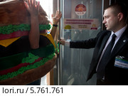 Охранник не пускает человека в костюме чизбургера в ресторан быстрого питания "Макдоналдс" на Пушкинской площади в Москве. Акция общественной организации "Правда о еде" по выдворению фастфуда из России (2014 год). Редакционное фото, фотограф Николай Винокуров / Фотобанк Лори