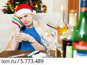 Молодой человек с похмелья в шапочке Санта Клауса. Стоковое фото, фотограф Яков Филимонов / Фотобанк Лори