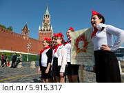 Юные пионеры из Тулы поют песни на фоне Спасской башни московского Кремля перед началом торжественной линейки, посвященной Дню пионерии и приему в пионеры на Красной площади города Москвы (2014 год). Редакционное фото, фотограф Николай Винокуров / Фотобанк Лори