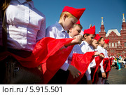Октябрята готовятся стать пионерами на торжественной линейке, посвященной Дню пионерии и приему в пионеры на Красной площади города Москвы (2014 год). Редакционное фото, фотограф Николай Винокуров / Фотобанк Лори