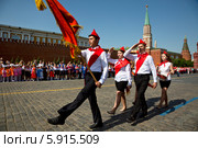 Пионеры выносят красное пионерское знамя на торжественной линейке, посвященной Дню пионерии и приему в пионеры на Красной площади города Москвы (2014 год). Редакционное фото, фотограф Николай Винокуров / Фотобанк Лори