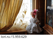 Большая кукла в нарядном белом платье на деревянном подоконнике (2014 год). Редакционное фото, фотограф Bala-Kate / Фотобанк Лори