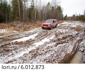 Красный полноприводный автомобиль на разбитой лесовозной дороге. Стоковое фото, фотограф Евгений Ткачёв / Фотобанк Лори