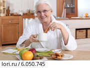 A mature woman having breakfast. Стоковое фото, фотограф Phovoir Images / Фотобанк Лори
