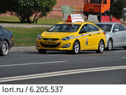 Желтый автомобиль такси двигается по Кремлевской набережной в Москве (2014 год). Редакционное фото, фотограф lana1501 / Фотобанк Лори