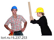 Engineer hitting a construction worker over the head. Стоковое фото, фотограф Phovoir Images / Фотобанк Лори