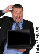 Amazed businessman holding a laptop computer with a screen left blank for your image. Стоковое фото, фотограф Phovoir Images / Фотобанк Лори
