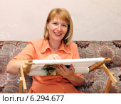 Улыбающаяся молодая женщина вышивает на рамке. Стоковое фото, фотограф EgleKa / Фотобанк Лори