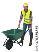 Labourer pushing a wheelbarrow. Стоковое фото, фотограф Phovoir Images / Фотобанк Лори
