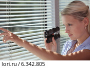 A spy peering through some blinds. Стоковое фото, фотограф Phovoir Images / Фотобанк Лори
