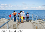 Люди на каменистом пляже. Силламяэ. Эстония (2014 год). Редакционное фото, фотограф Александр Щепин / Фотобанк Лори