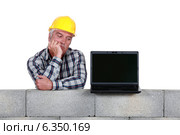 A bored mature mason with a laptop. Стоковое фото, фотограф Phovoir Images / Фотобанк Лори