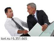 Serious businessman pointing at a colleague's laptop. Стоковое фото, фотограф Phovoir Images / Фотобанк Лори