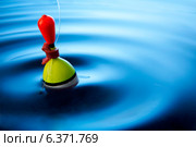 Multi coloured fishing float bobbing in water making ripples. Стоковое фото, агентство Ingram Publishing / Фотобанк Лори