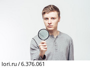 Man looking through a magnifying glass. Стоковое фото, агентство Ingram Publishing / Фотобанк Лори