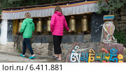 Girls spinning prayer wheels at Drepung Monastery, Lhasa, Tibet, China (2012 год). Стоковое фото, агентство Ingram Publishing / Фотобанк Лори
