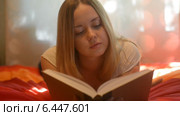 Девушка читает книгу на постели. Стоковое видео, видеограф Валерия Лузина / Фотобанк Лори