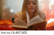 Девушка читает книгу на постели. Стоковое видео, видеограф Валерия Лузина / Фотобанк Лори
