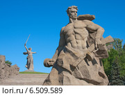 Скульптура советского воина «Стоять насмерть!» на фоне монумента «Родина-мать зовёт!» Скульптор Евгений Вучетич (2013 год). Редакционное фото, фотограф Андрей Ижаковский / Фотобанк Лори
