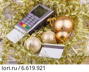 Золотистые ёлочные украшения, торговый терминал и банковские карты. Стоковое фото, фотограф Станислав Виноградов / Фотобанк Лори