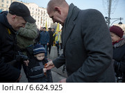 Олимпийский чемпион и депутат Госдумы Александр Карелин дарит георгиевскую ленту мальчику во время шествия в рамках акции "Мы едины" в российский праздник День народного единства на Тверской улице, Москва 4 ноября 2014. Редакционное фото, фотограф Николай Винокуров / Фотобанк Лори