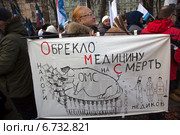 Митинг против реформы здравоохранения, закрытия больниц и сокращения рабочих мест. Женщина держит плакат на митинге в центре города Москвы, Россия, 30 ноября 2014. Редакционное фото, фотограф Николай Винокуров / Фотобанк Лори