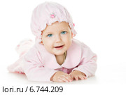Маленькая девочка в розовой одежде и чепчике лежит на белом фоне. Стоковое фото, фотограф Типляшина Евгения / Фотобанк Лори