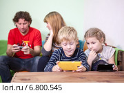 Вся семья сидит увлекшись телефонами и смартфонами. Стоковое фото, фотограф Кекяляйнен Андрей / Фотобанк Лори