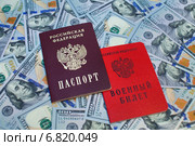 Военный билет и паспорт гражданина Российской Федерации на фоне из 100-долларовых купюр. Стоковое фото, фотограф Александр Тарасенков / Фотобанк Лори
