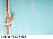 Морской канат с узлом на бирюзовом деревянном фоне. Стоковое фото, фотограф Сергей Лабутин / Фотобанк Лори