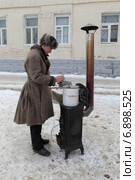 Коломна, молодой человек в старинной одежде готовит на печи сбитень (2015 год). Редакционное фото, фотограф Дмитрий Неумоин / Фотобанк Лори