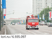 Пожарная машина движется по празднично украшенному Центральному проспекту (г. Зеленоград) на фоне надписи "С праздником" (2012 год). Редакционное фото, фотограф Сайганов Александр / Фотобанк Лори