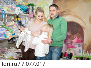 Беременная женщина с семьёй покупает детскую одежду в магазине. Стоковое фото, фотограф Наталья Давыдова / Фотобанк Лори