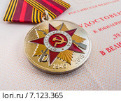 Юбилейная медаль «70 лет Победы в Великой Отечественной войне 1941—1945 гг.» на удостоверении крупным планом. Малая глубина резкости. Стоковое фото, фотограф Владимир Сергеев / Фотобанк Лори