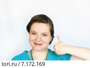Портрет молодой привлекательной женщины на светлом фоне, которая показывает большой палец вверх. Стоковое фото, фотограф Наталья Федорова / Фотобанк Лори