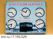 Информационный плакат с указанием времени намаза висит на стене мечети Шейха Муслихиддина в городе Худжанд, Таджикистан (2015 год). Редакционное фото, фотограф Николай Винокуров / Фотобанк Лори