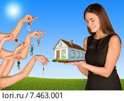 Деловая женщина держит в руках дом и множество рук преподносят ей ключи. Стоковое фото, фотограф Кирилл Черезов / Фотобанк Лори