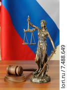 Российское правосудие - судейский молоток и фигурка Фемиды на фоне Российского флага. Стоковое фото, фотограф Денис Ларкин / Фотобанк Лори