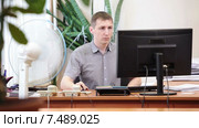 Бизнесмен с телефоном в руках подходит к столу, садится и начинает печатать на клавиатуре. Стоковое видео, видеограф Кекяляйнен Андрей / Фотобанк Лори