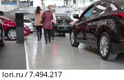 Автосалон по продаже новых автомобилей. Продавец с покупателями ходят среди машин (2015 год). Редакционное видео, видеограф Кекяляйнен Андрей / Фотобанк Лори