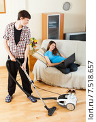 Man cleaning while wife lying with notebook. Стоковое фото, фотограф Яков Филимонов / Фотобанк Лори