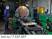 Industrial processing of metal on big turning lathe machine Завод металлоконструкций, механический участок, токарный цех, токарь обтачивает стальную деталь на большом токарном станке (2015 год). Редакционное фото, фотограф Владимир Григорьев / Фотобанк Лори