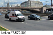 Машина Скорой помощи с включёнными спецсигналами движется по Кремлёвской набережной (2013 год). Редакционное фото, фотограф Ольга Коцюба / Фотобанк Лори